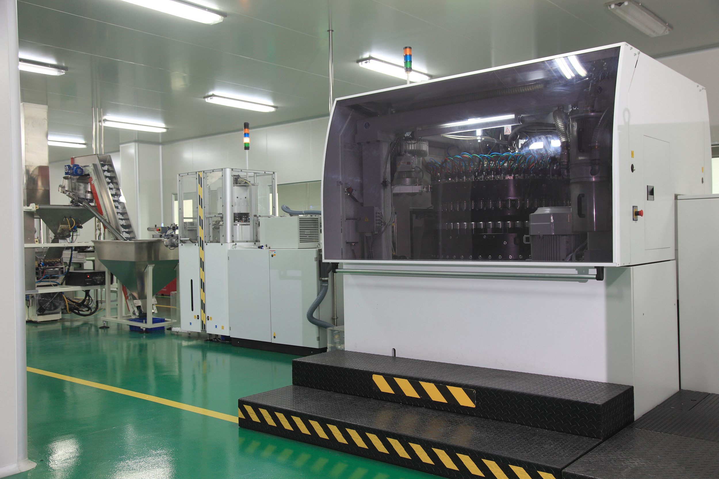 Vue intérieure d'une usine avec une machine de moulage par injection sophistiquée, illustrant l'automatisation industrielle moderne.